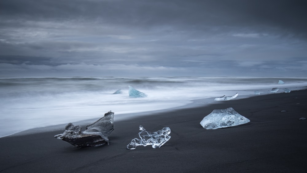foto in scala di grigi di rocce sulla spiaggia