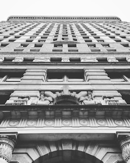 Exterior view of the Chrysler Building in grayscale, serving as a dramatic background