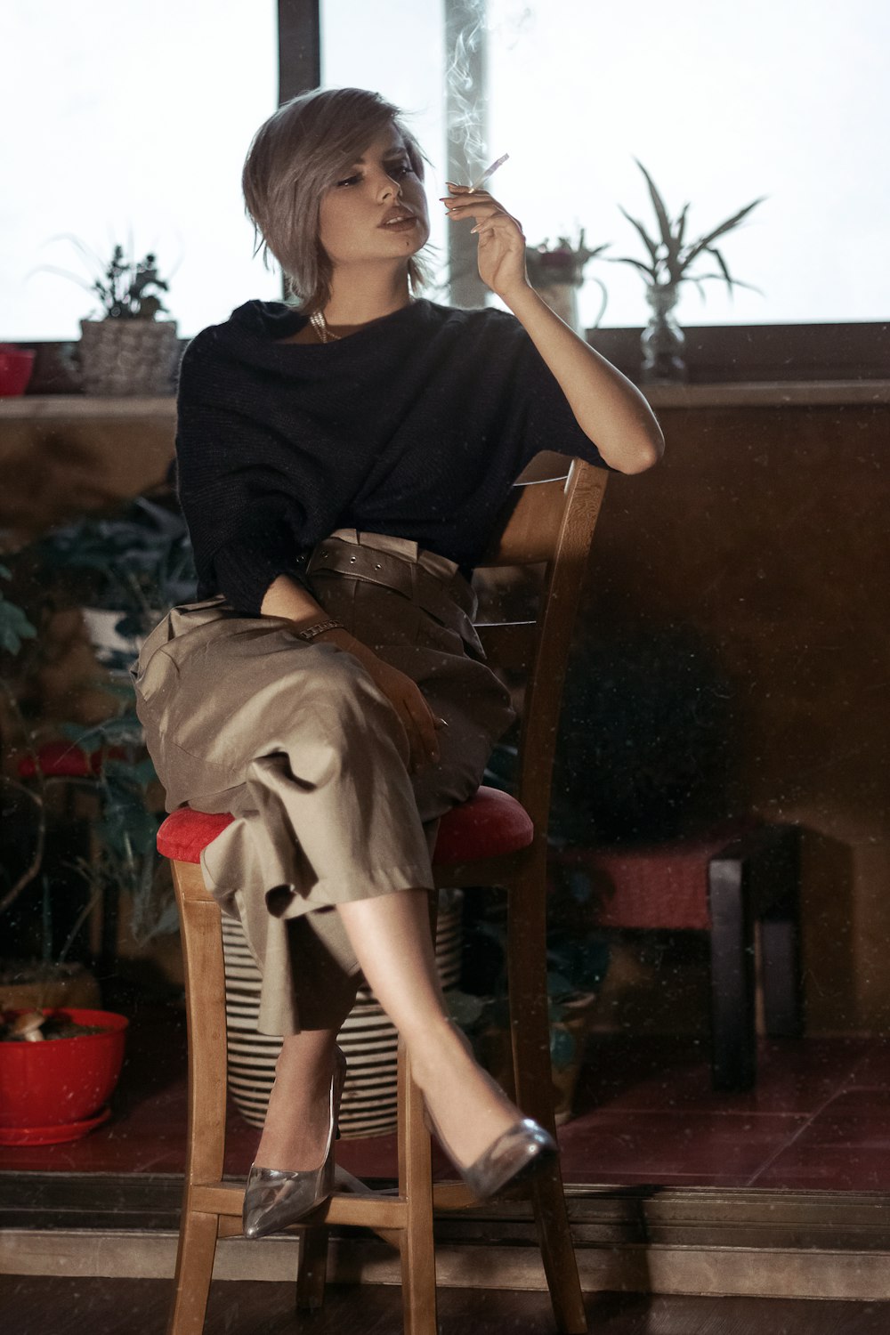 woman in black t-shirt sitting on brown wooden armchair