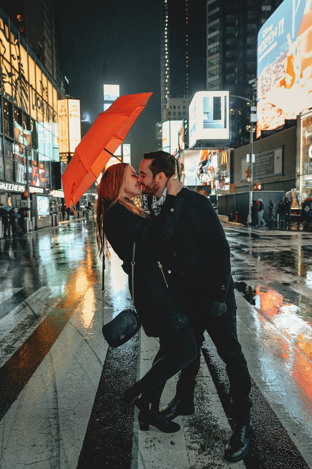 man in black jacket holding umbrella walking on sidewalk during daytime