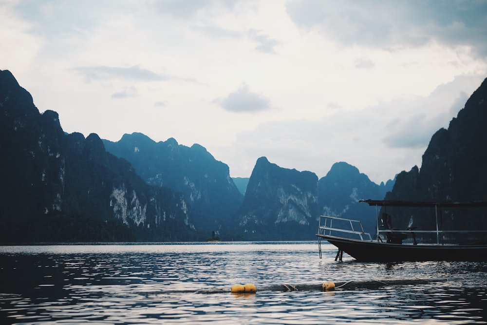 boat on water near mountain during daytime