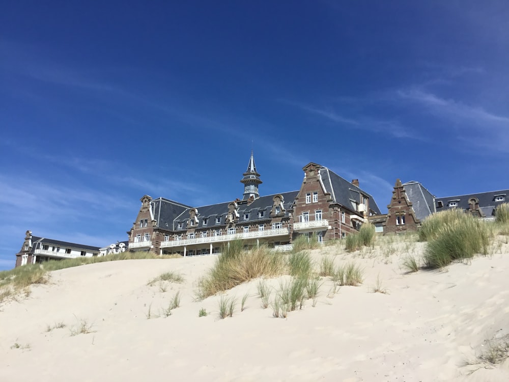 white and black house on brown sand under blue sky during daytime