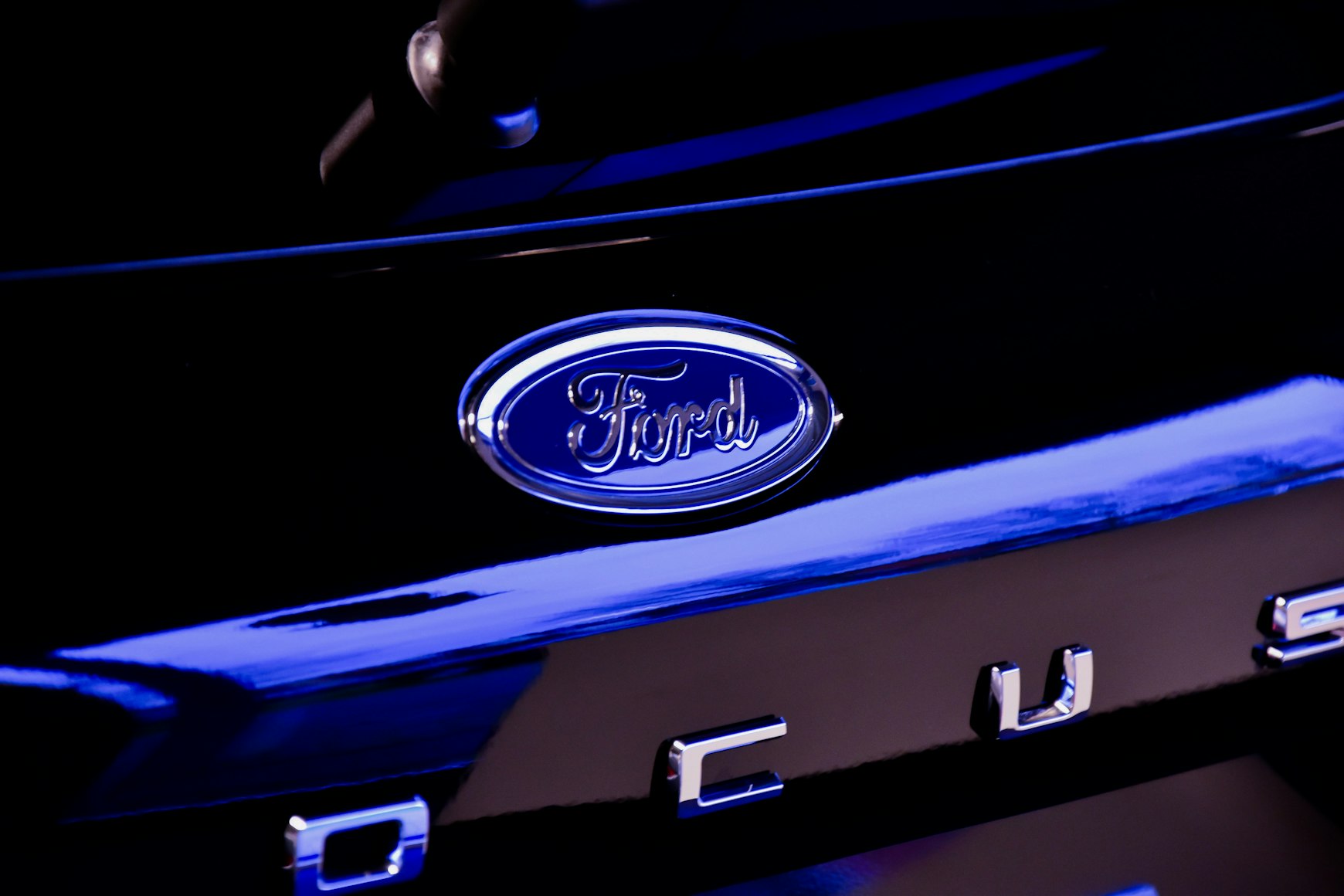 Blue Ford logo zoomed in on a Ford Focus sedan.