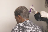 Stylist applying nourishing hair treatment with gentle focus and care.