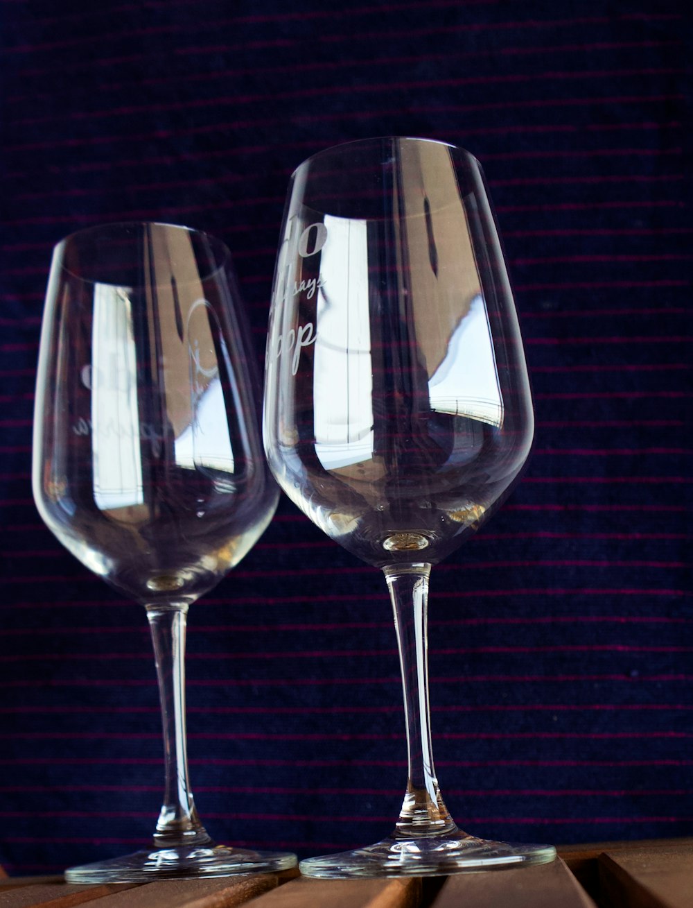 2 clear wine glasses on black surface