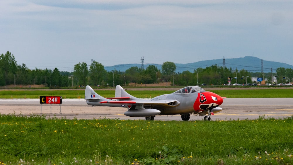 red and white airplane on green grass field during daytime