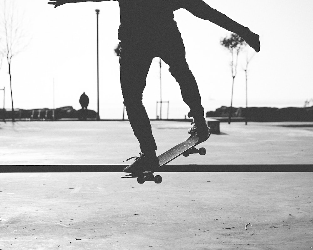 man in black pants and black shoes playing skateboard