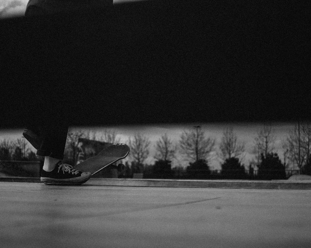 person in black and white sneakers standing on road during daytime