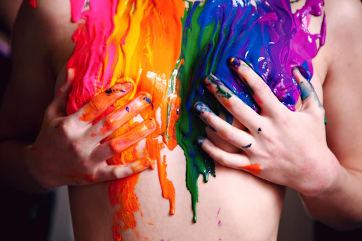 person with green yellow and pink paint on hand