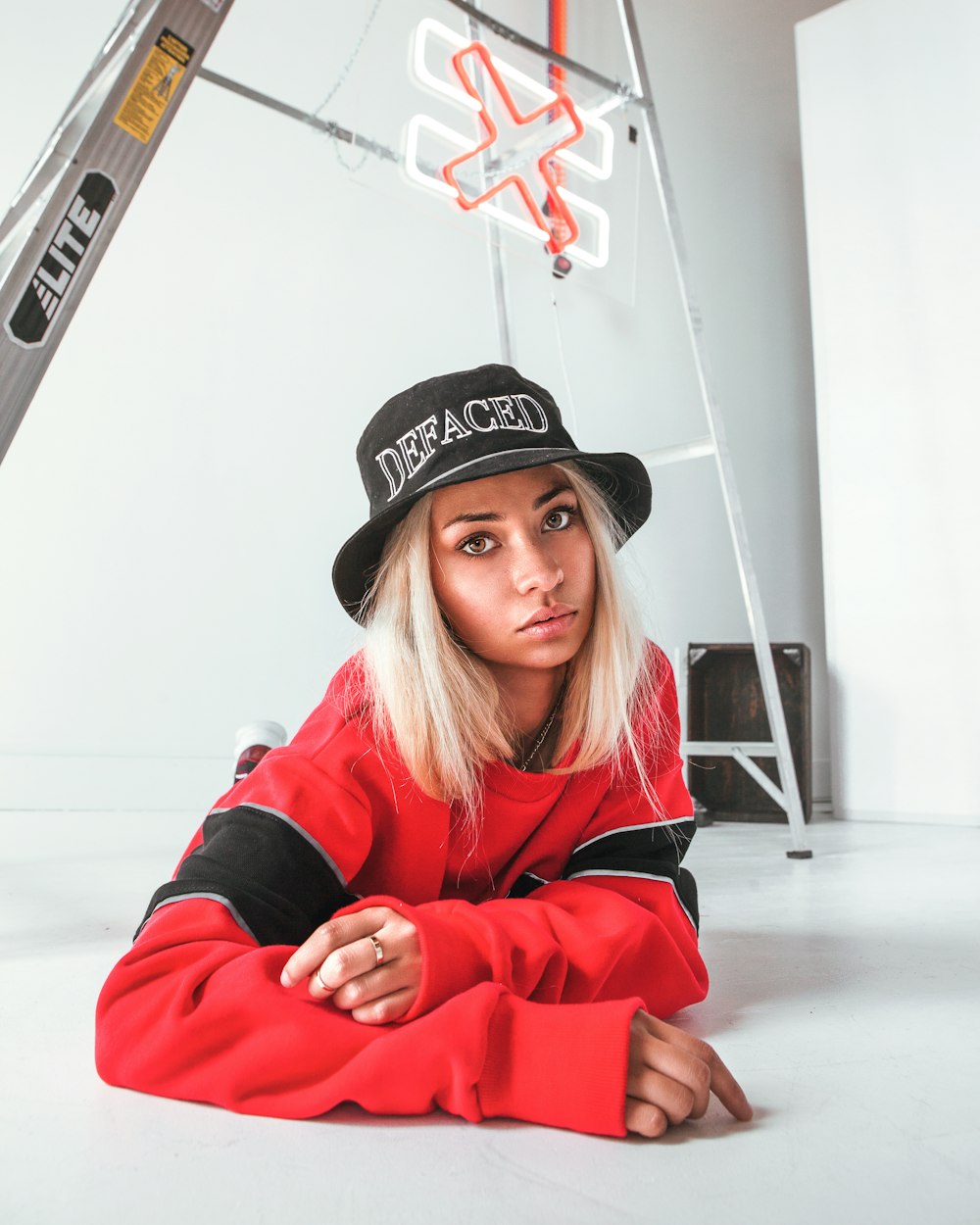 woman in black and white fitted cap and red jacket