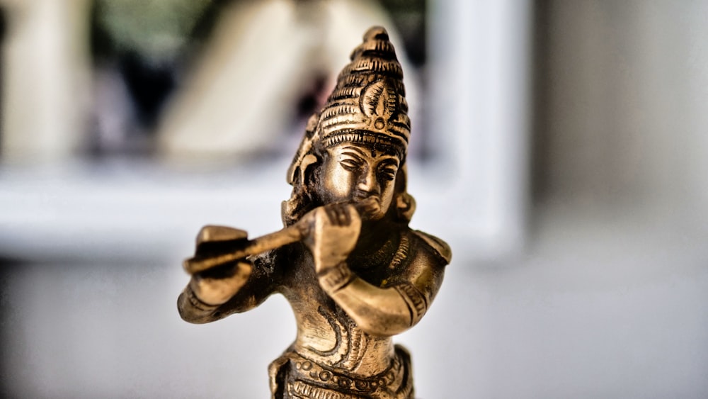 gold human figurine in tilt shift lens