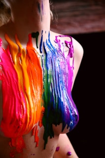 A vibrant close-up of a colorful custom t-shirt with splashes of cyan and magenta paint.