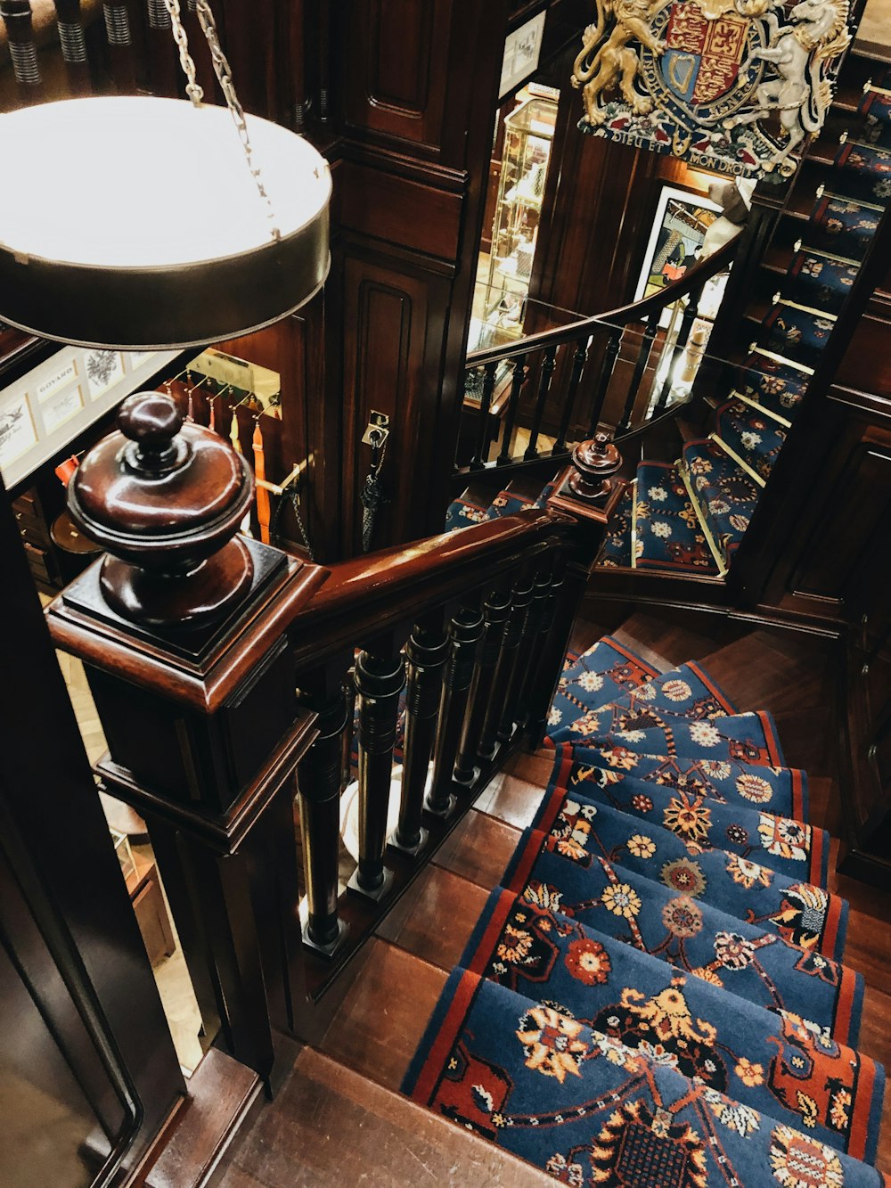 brown wooden staircase with blue and red floral carpet