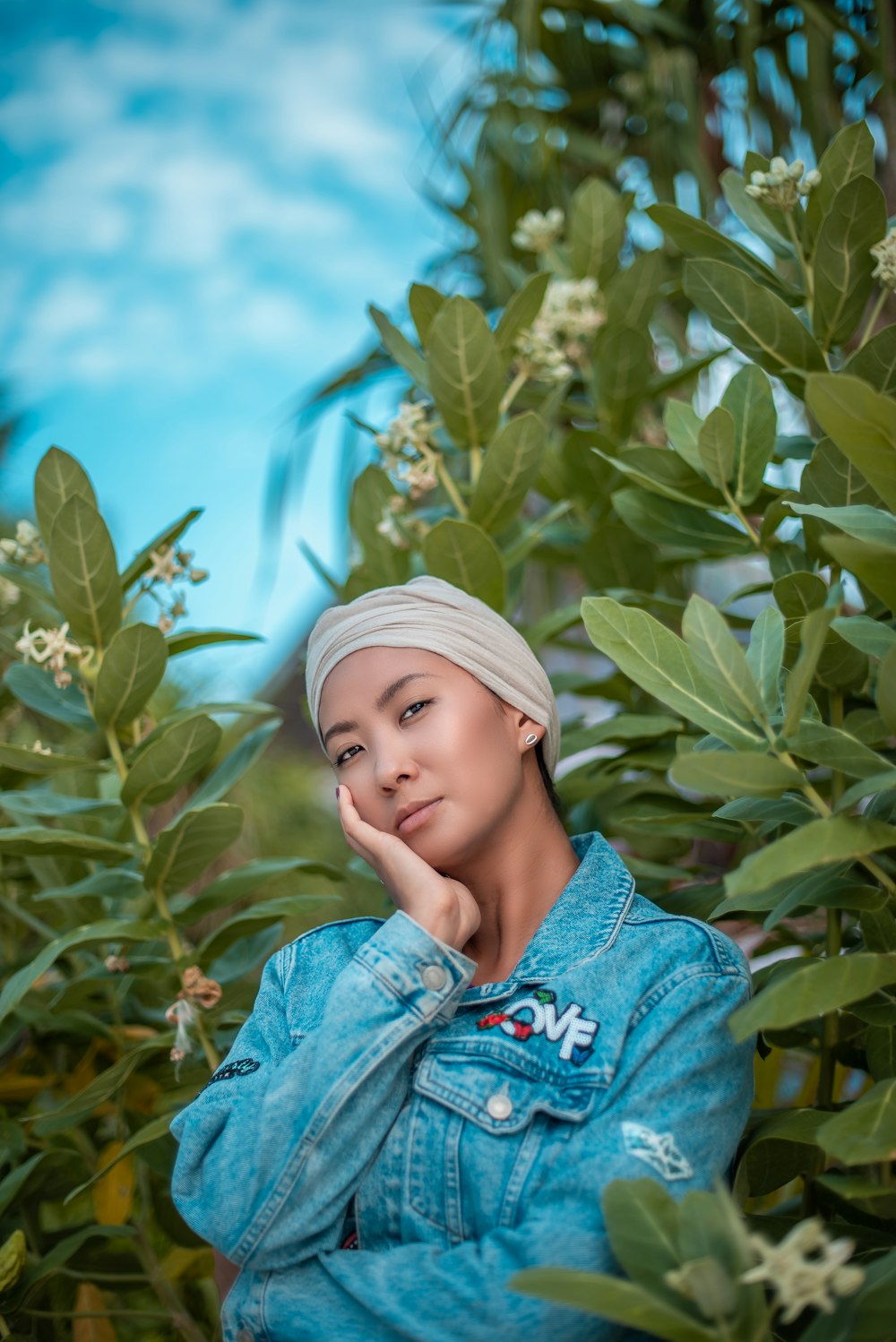 boy in blue denim jacket standing beside green plant during daytime