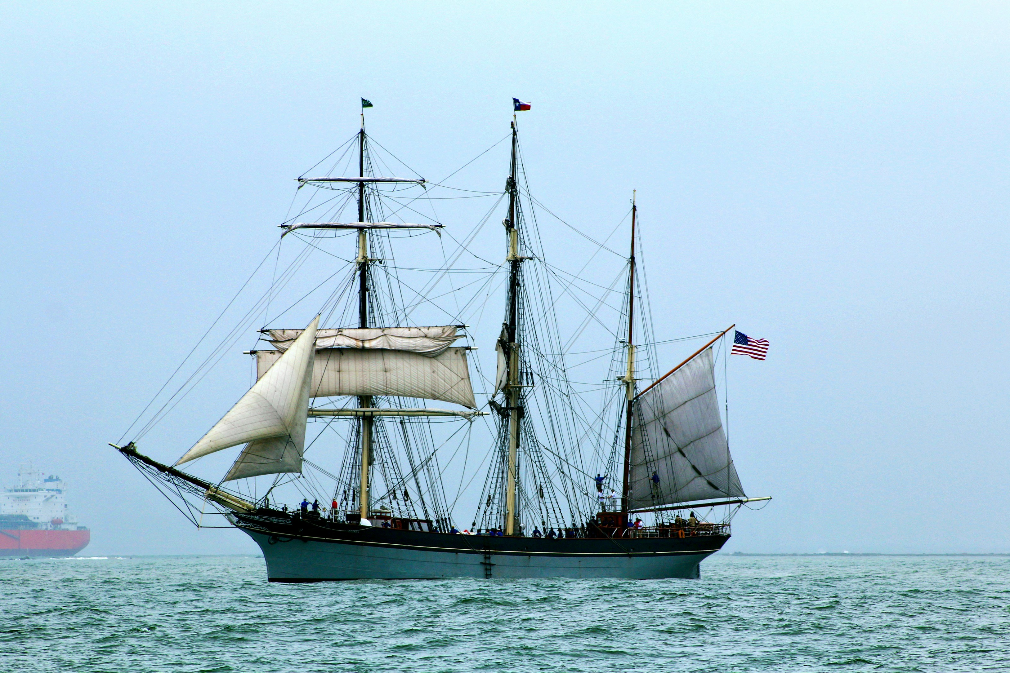 brown and white sail boat on body of water during daytime