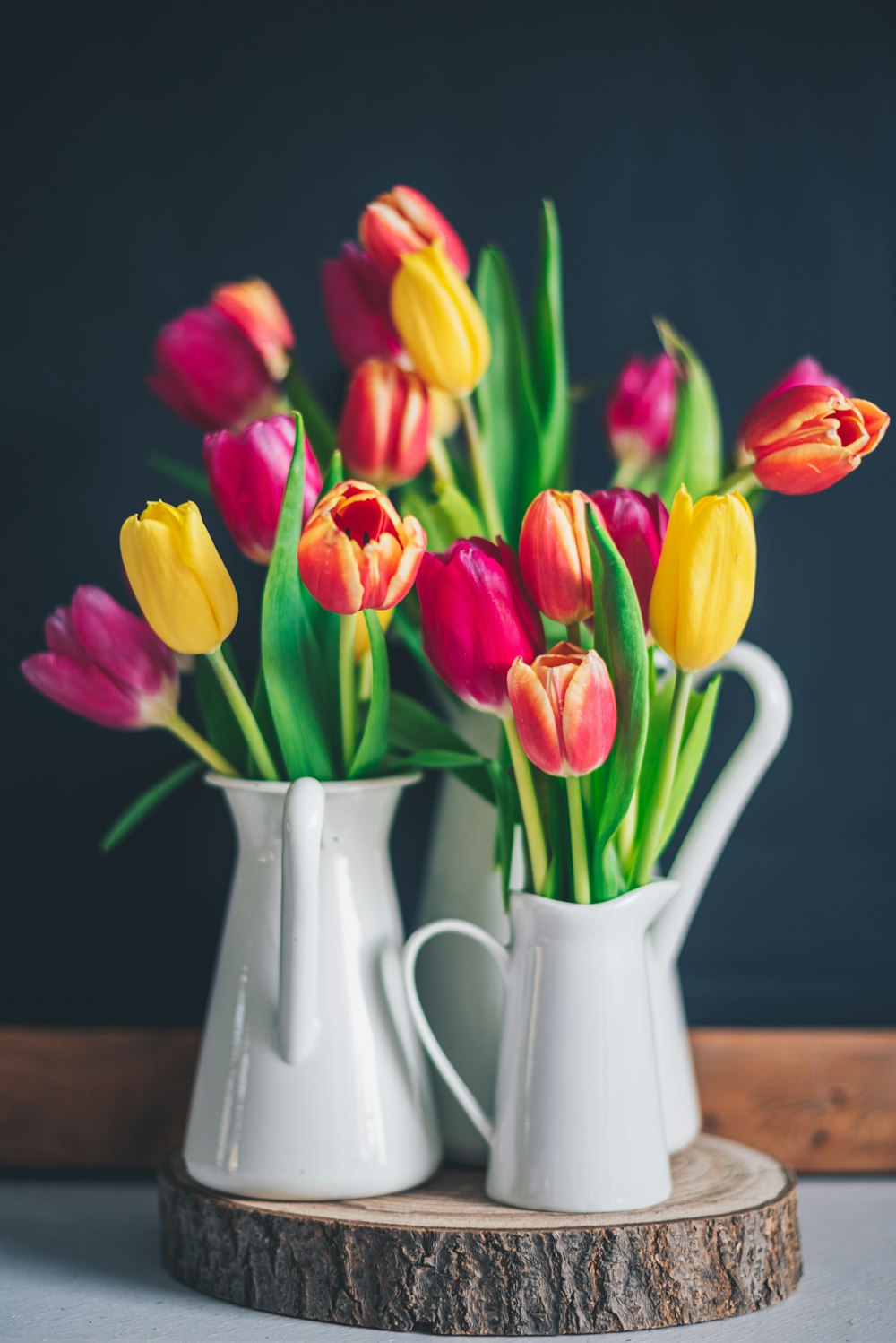 Tulipanes rojos y amarillos en jarrón de cerámica blanca