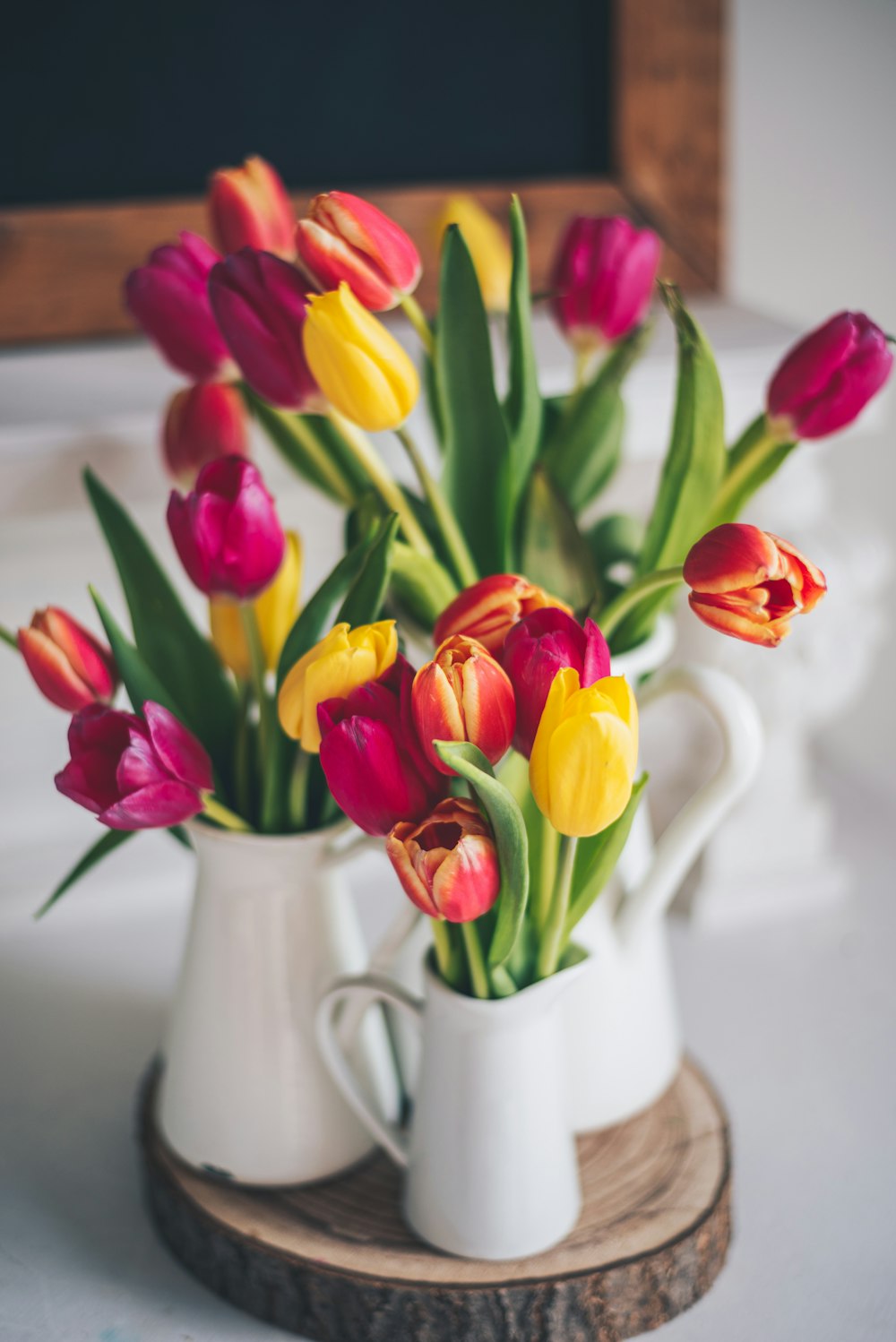 Tulipanes rojos y amarillos en jarrón de cerámica blanca