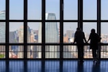 Two businesspeople shaking hands with city skylines of Lagos and Washington D.C. in the background.