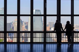 Business professionals shaking hands overlooking a modern city skyline.