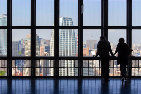 A professional handshake between international business partners overlooking a city skyline.