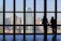 A smiling couple standing in front of a luxury New York City penthouse with skyline views.
