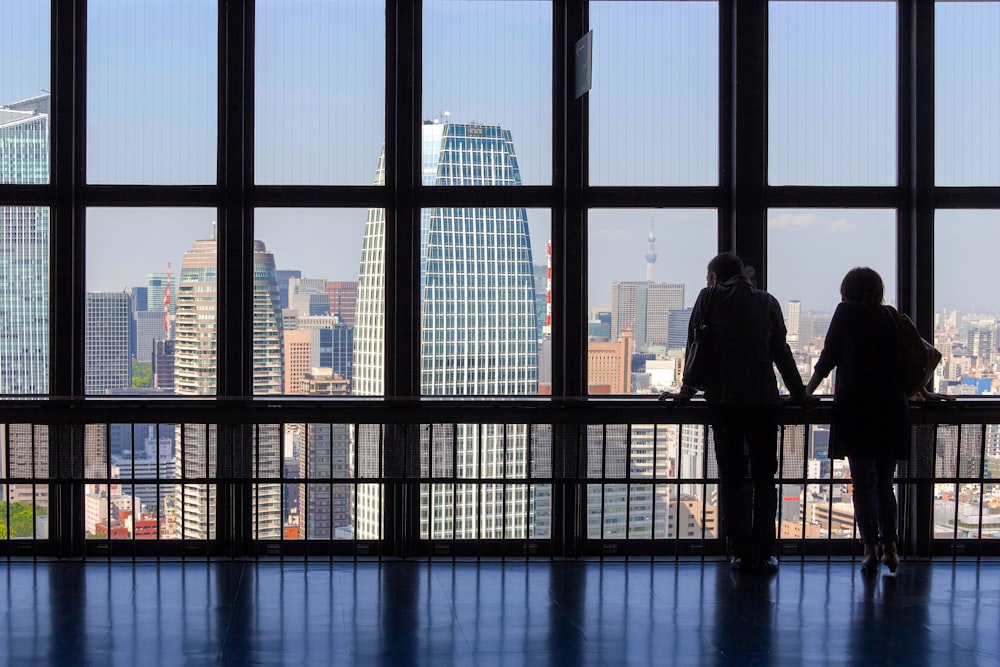 silhouette of man standing in front of glass building during daytime