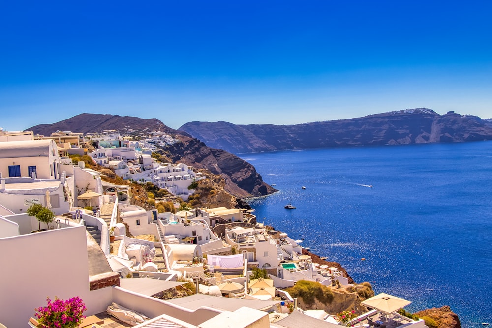 white and brown houses near blue sea under blue sky during daytime