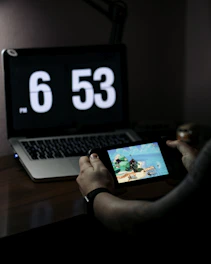 person using macbook pro on brown wooden table