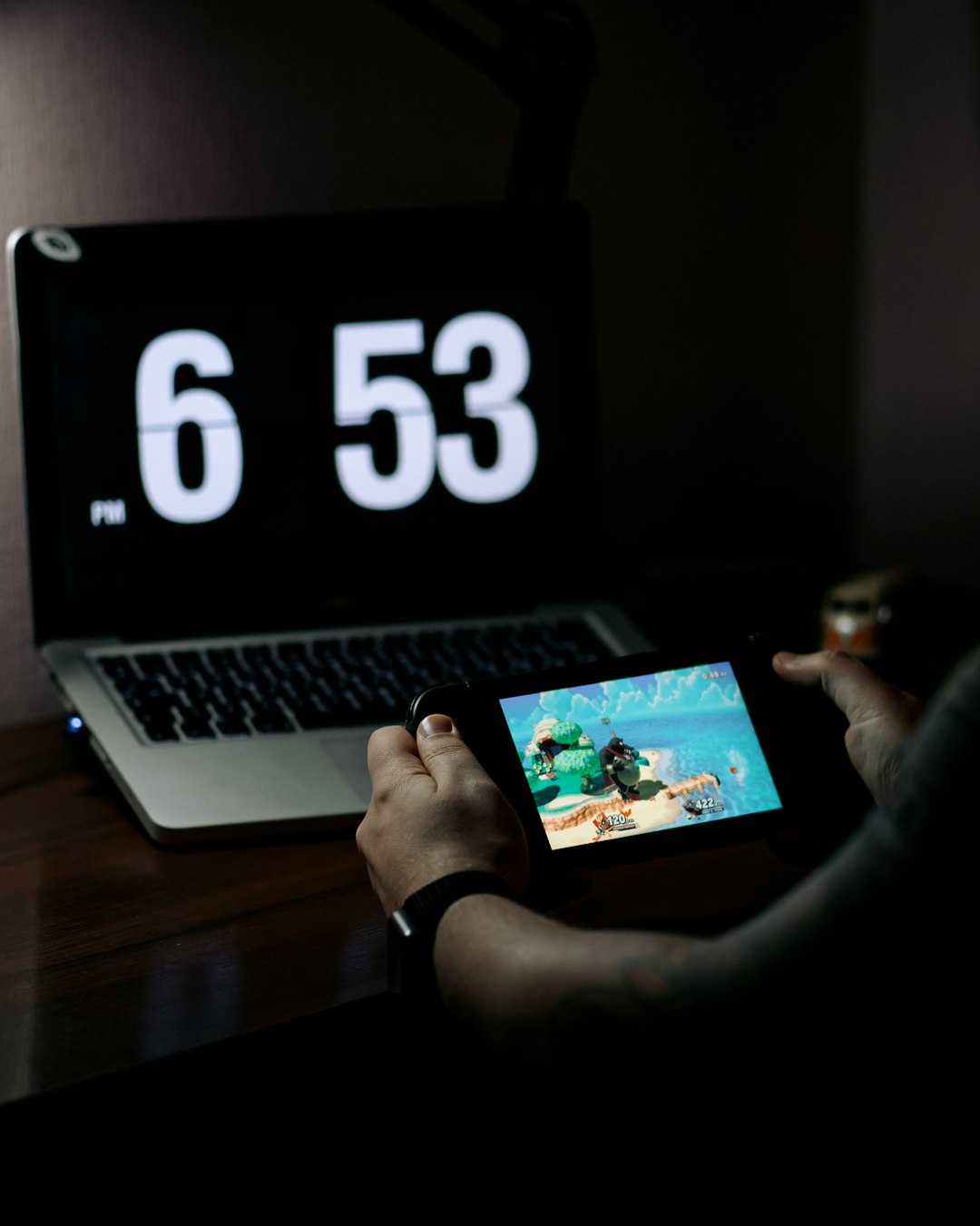 person using macbook pro on brown wooden table