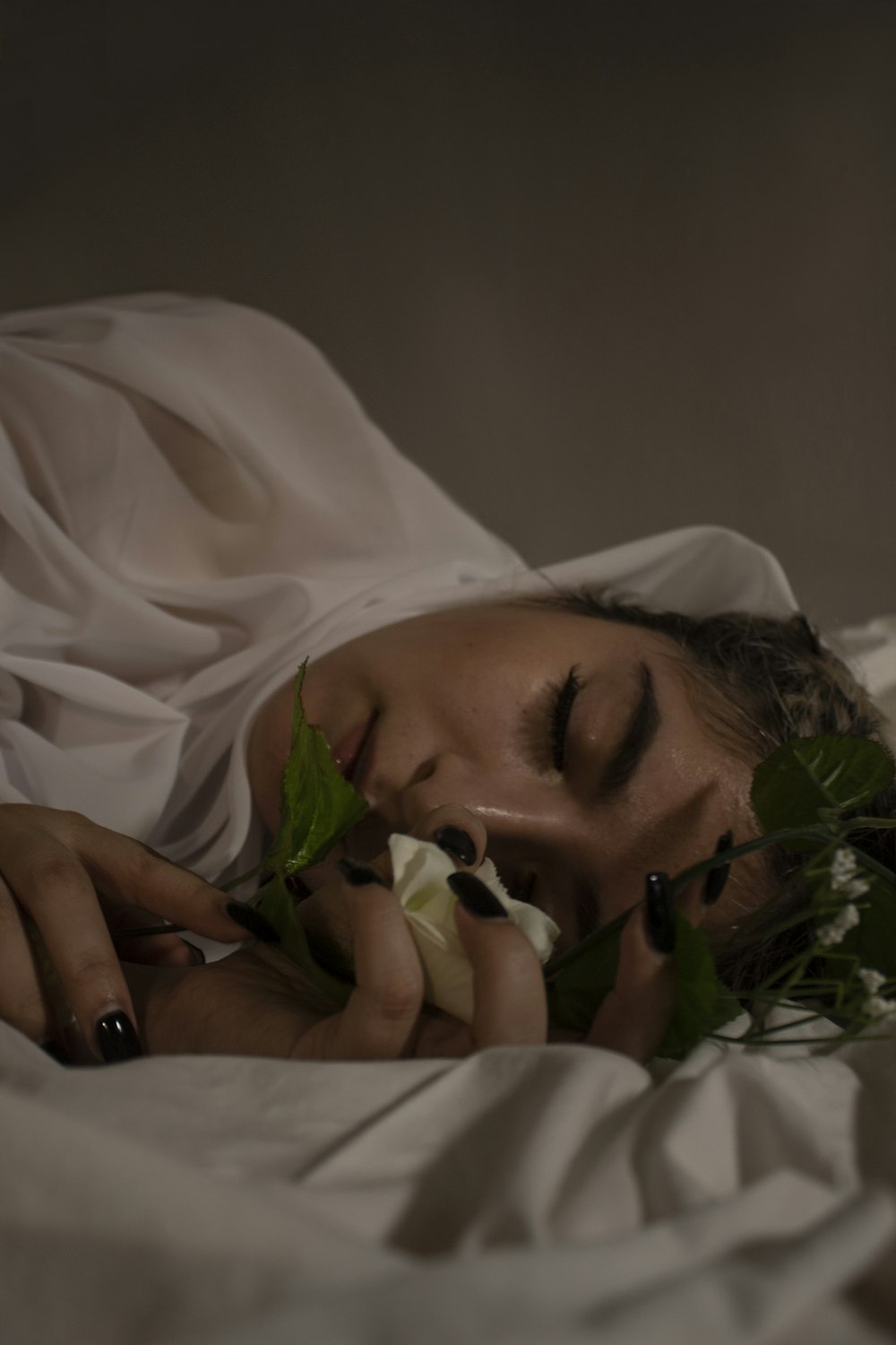 woman in white hijab holding green plant