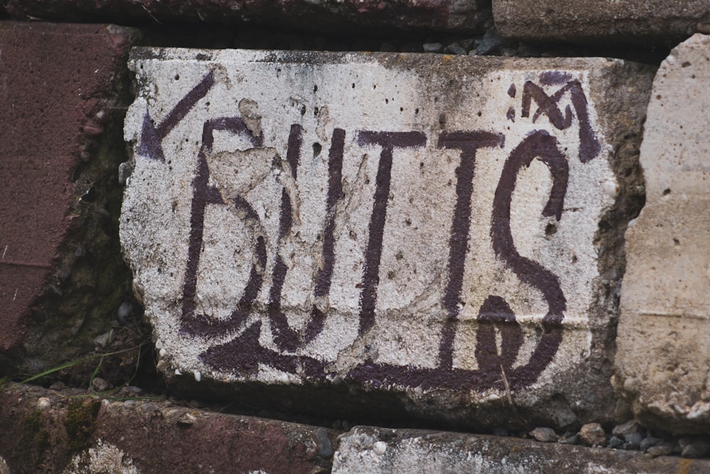 un muro di mattoni con graffiti scritti su di esso
