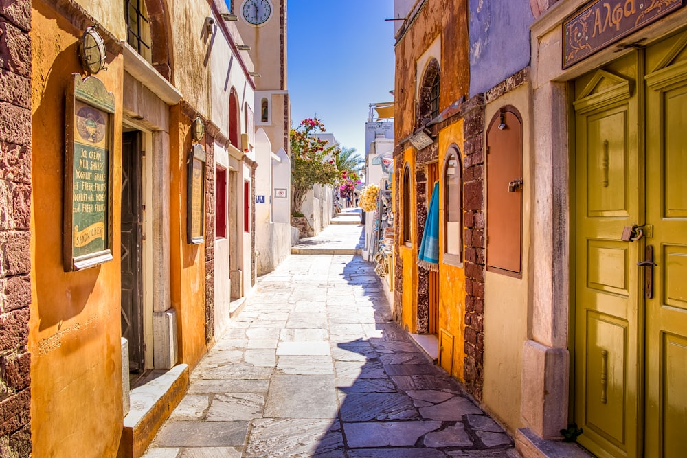 empty street between brown concrete buildings during daytime