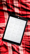 A digital monthly calendar displayed on a tablet with pink and gold accents