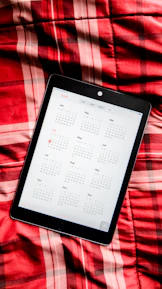A smiling client reviewing available dates on a sleek digital calendar on a tablet.
