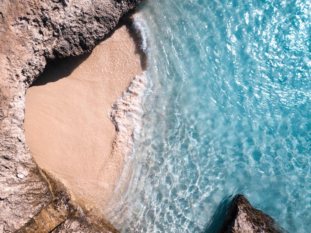 aerial view of ocean waves crashing on shore during daytime