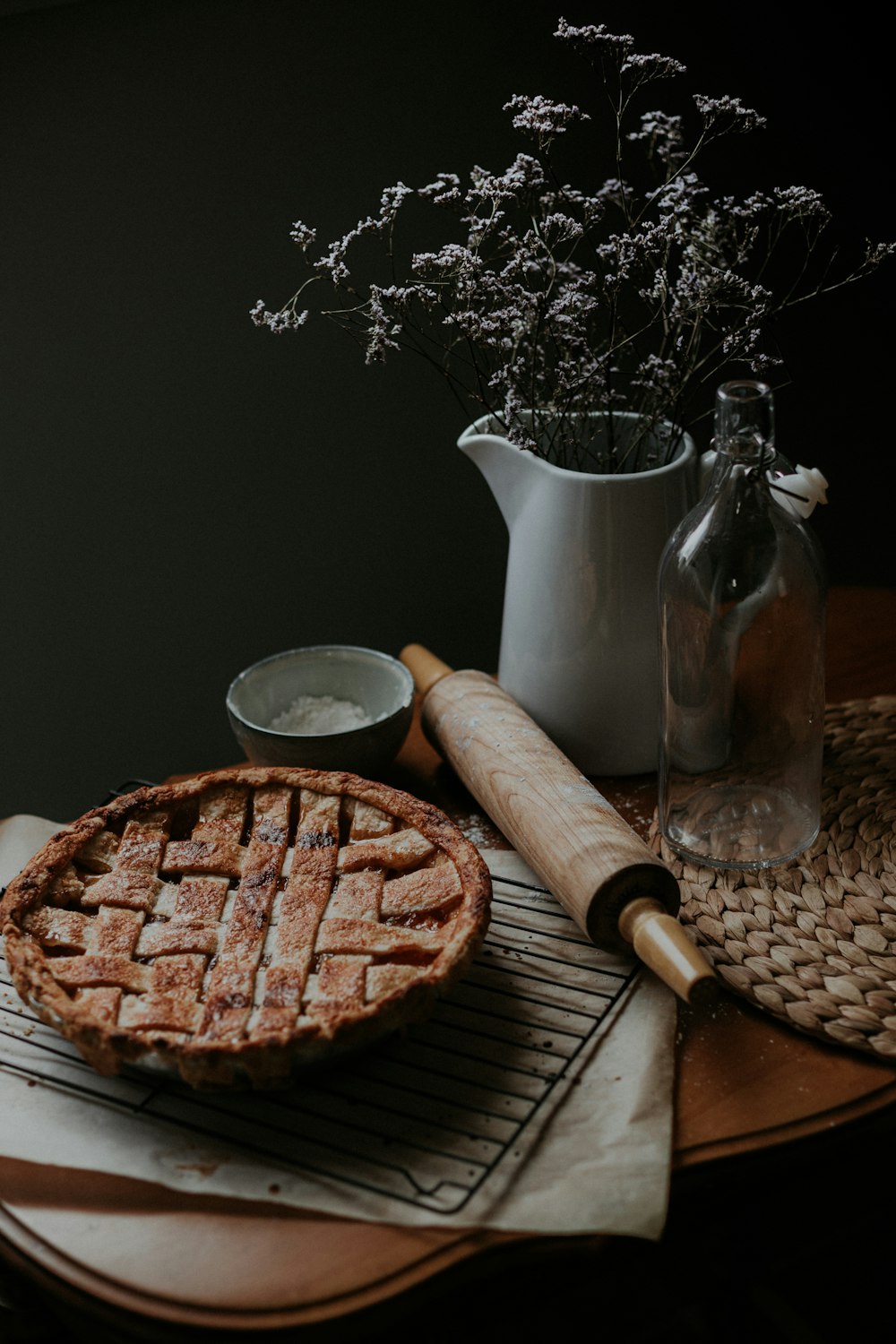 白い水差しの横の茶色の木製のまな板に茶色のパン