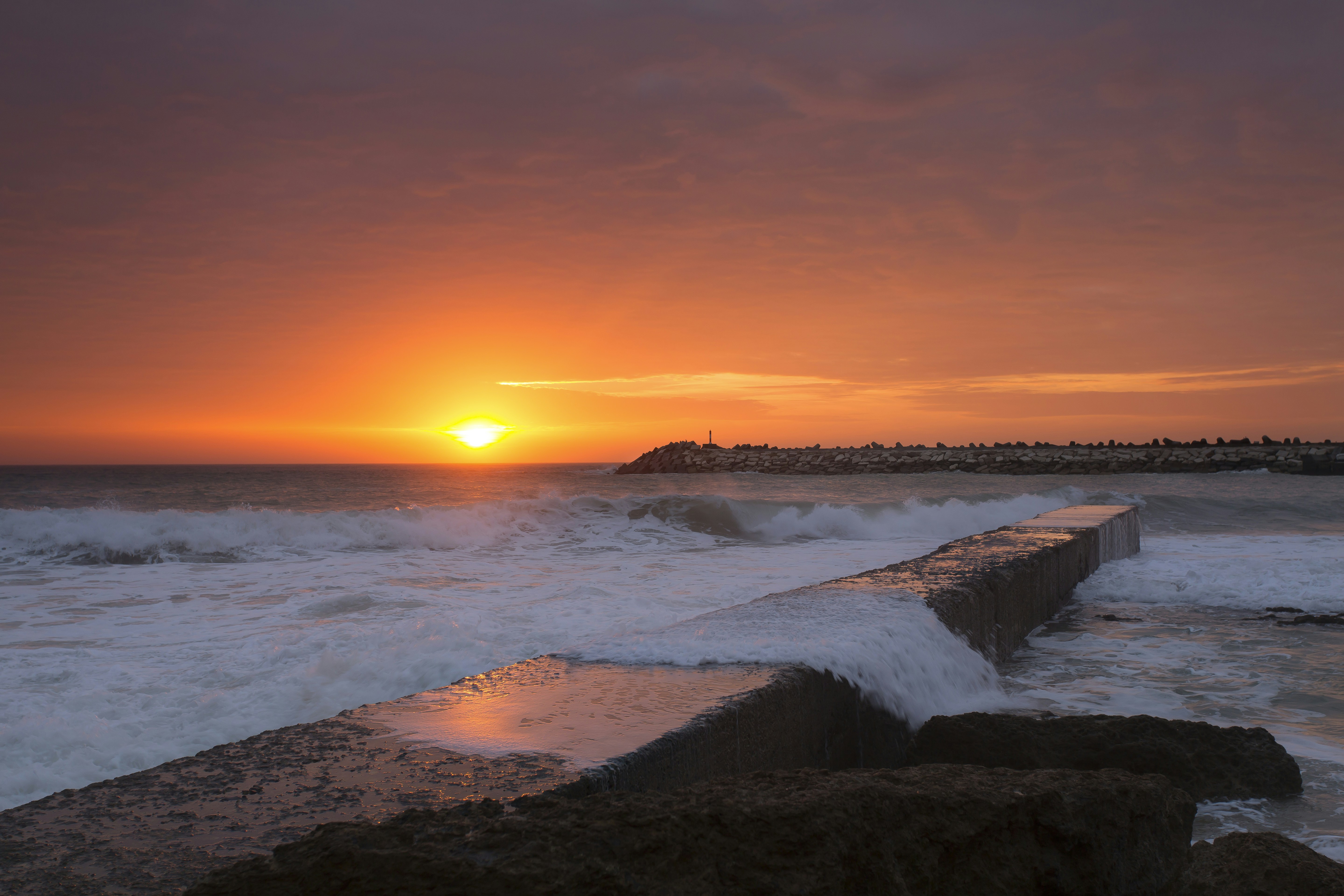 Onde dell'oceano che si infrangono sulla riva durante il tramonto