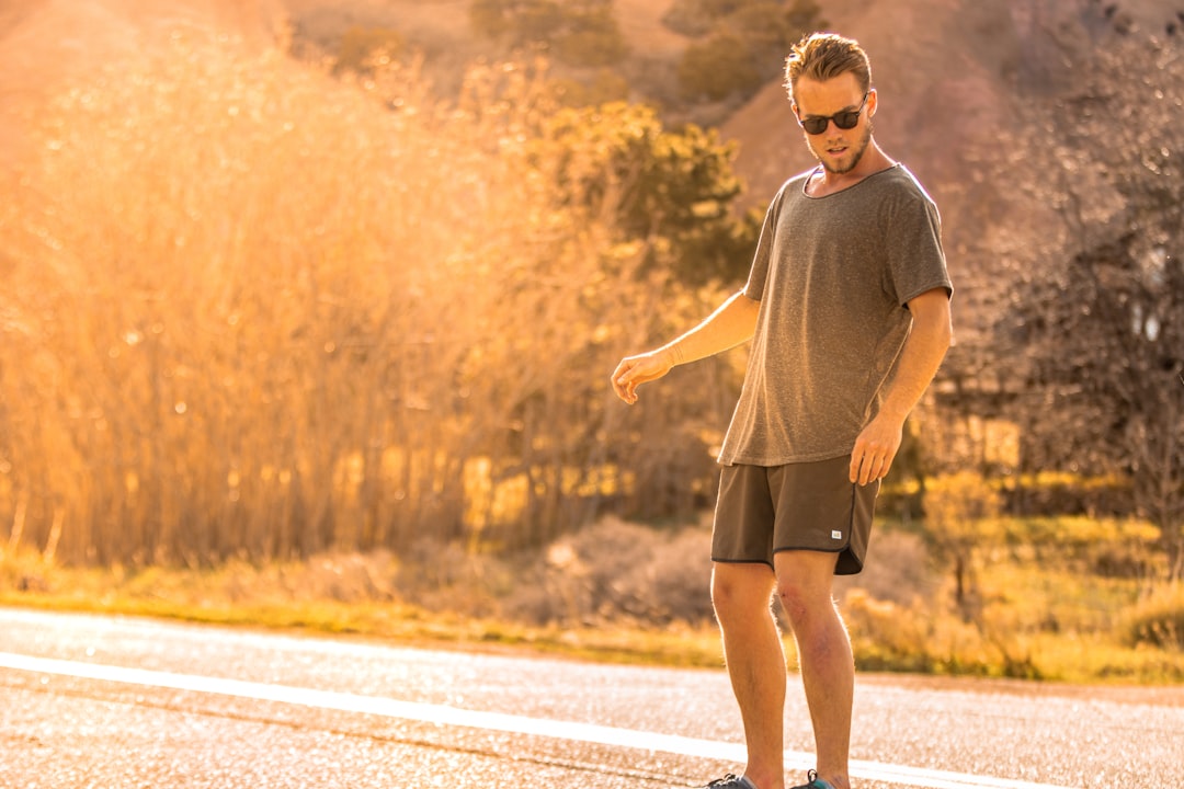 man in gray crew neck t-shirt running on road during daytime