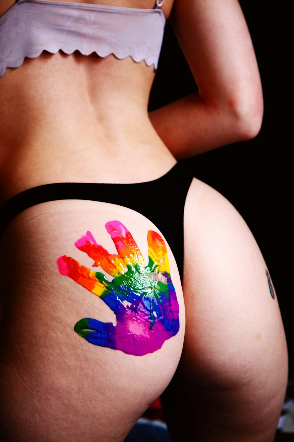 donna in canotta nera con tatuaggio farfalla rosa, blu e giallo
