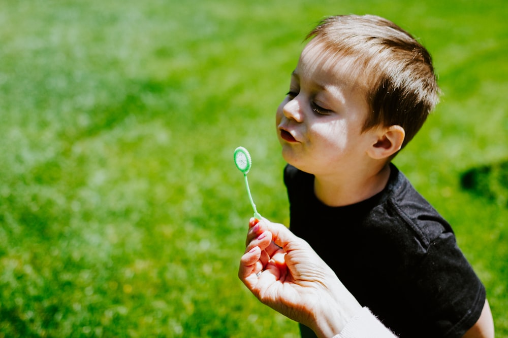 girl in black crew neck shirt blowing bubbles