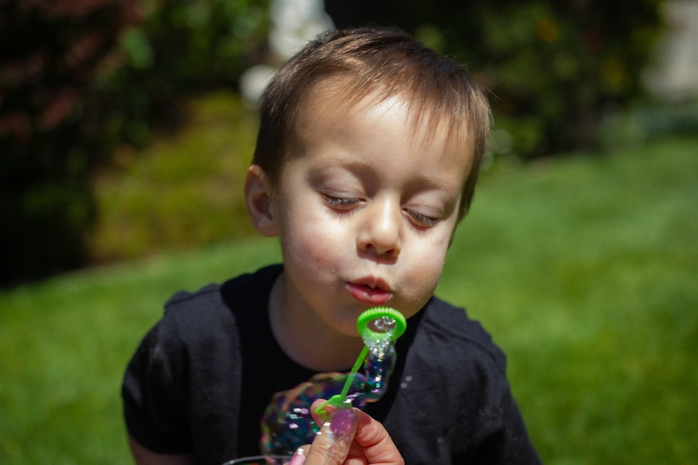 boy in black shirt blowing bubbles