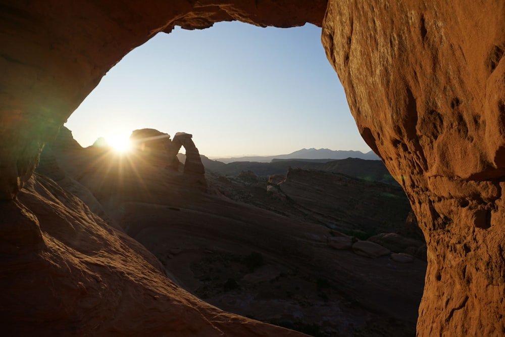 person in black jacket sitting on rock formation during daytime