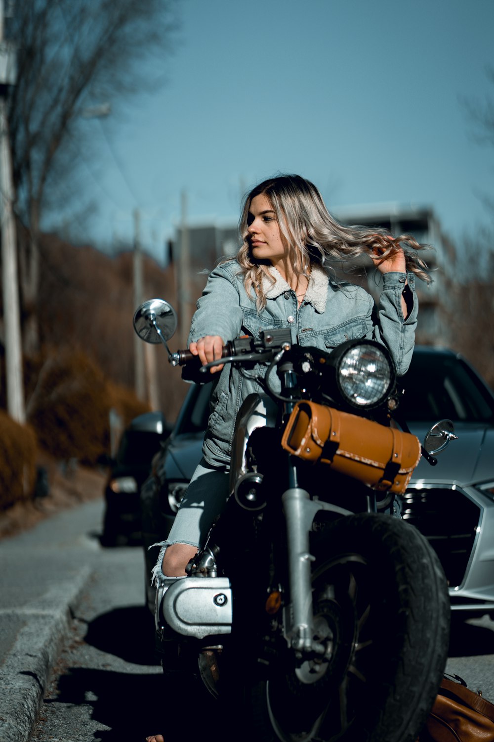 woman in white long sleeve shirt riding on motorcycle during daytime