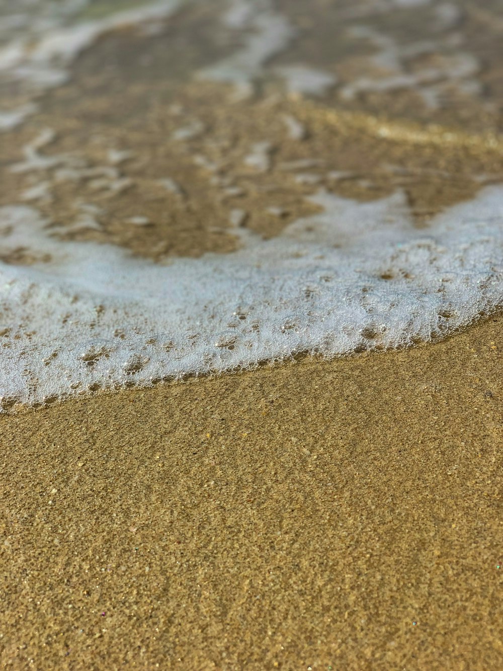 brown sand near body of water during daytime