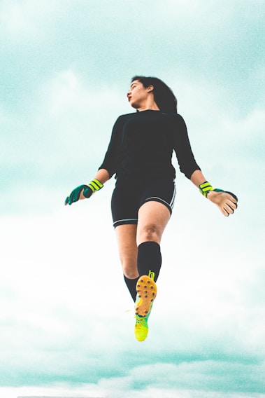 A dynamic shot of a football player mid-air, muscles tense, under stadium lights with a dark, moody background.
