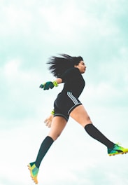 An athlete mid-jump wearing a shock-absorbing knee brace, highlighting the brace’s cushioning in action.