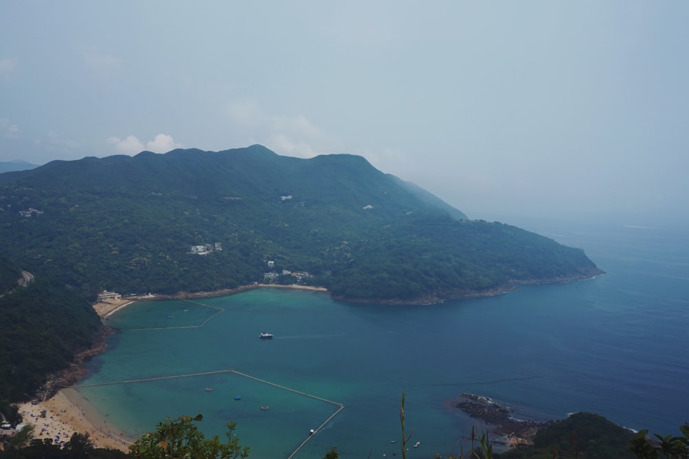 green mountain beside body of water during daytime