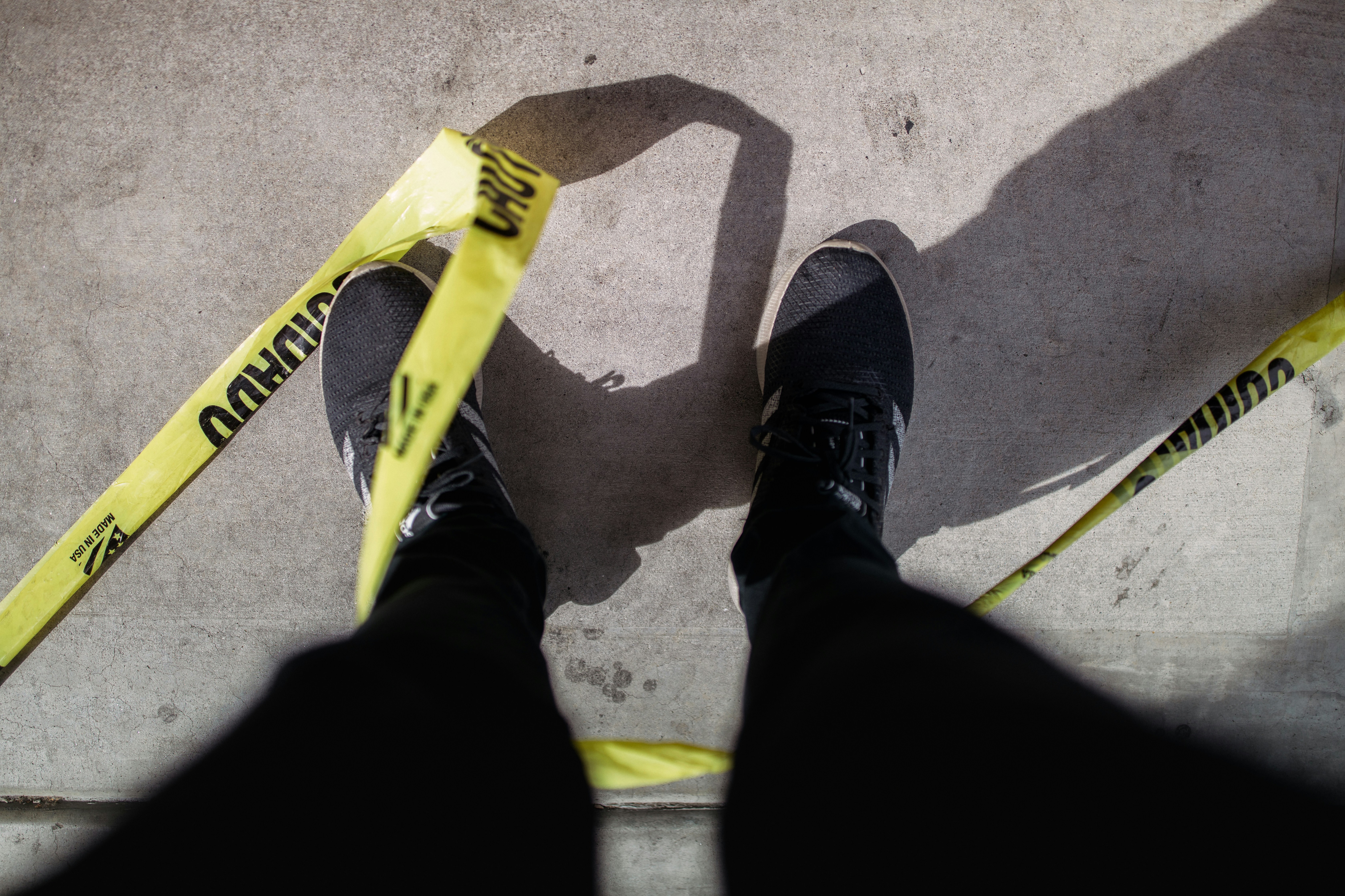 person wearing black pants and gray and black sneakers