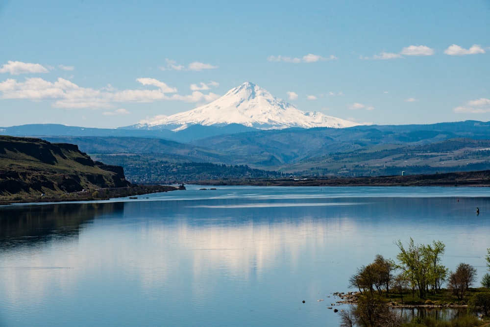 body of water near mountain under blue sky during daytime