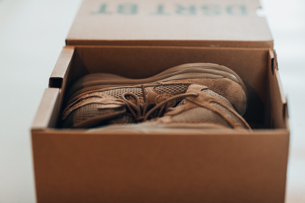 brown and white running shoes in box